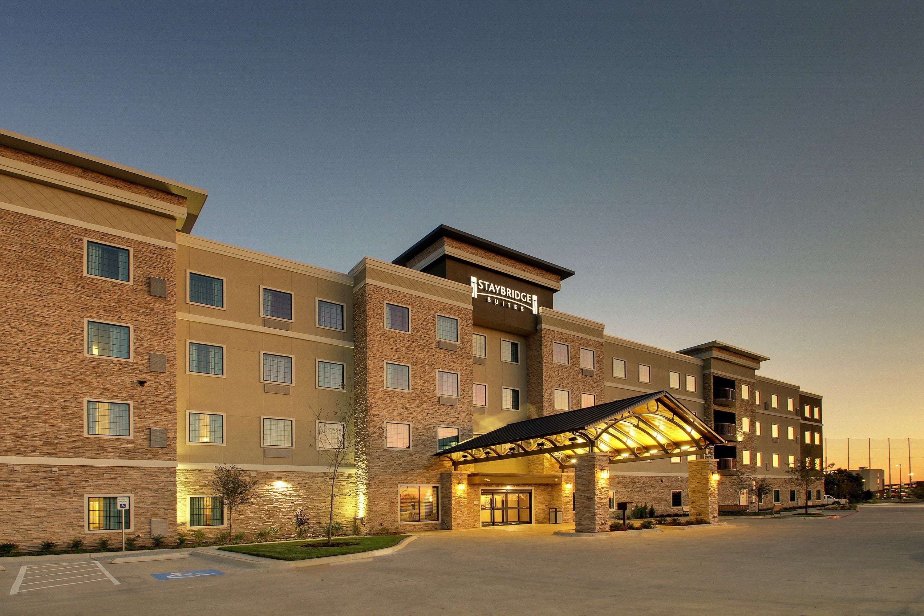 A Staybridge Suites hotel with a modern design, featuring a covered entrance and multiple floors.