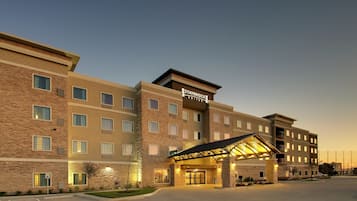 Un hôtel Staybridge Suites au design moderne, doté d’une entrée abritée et de plusieurs étages.