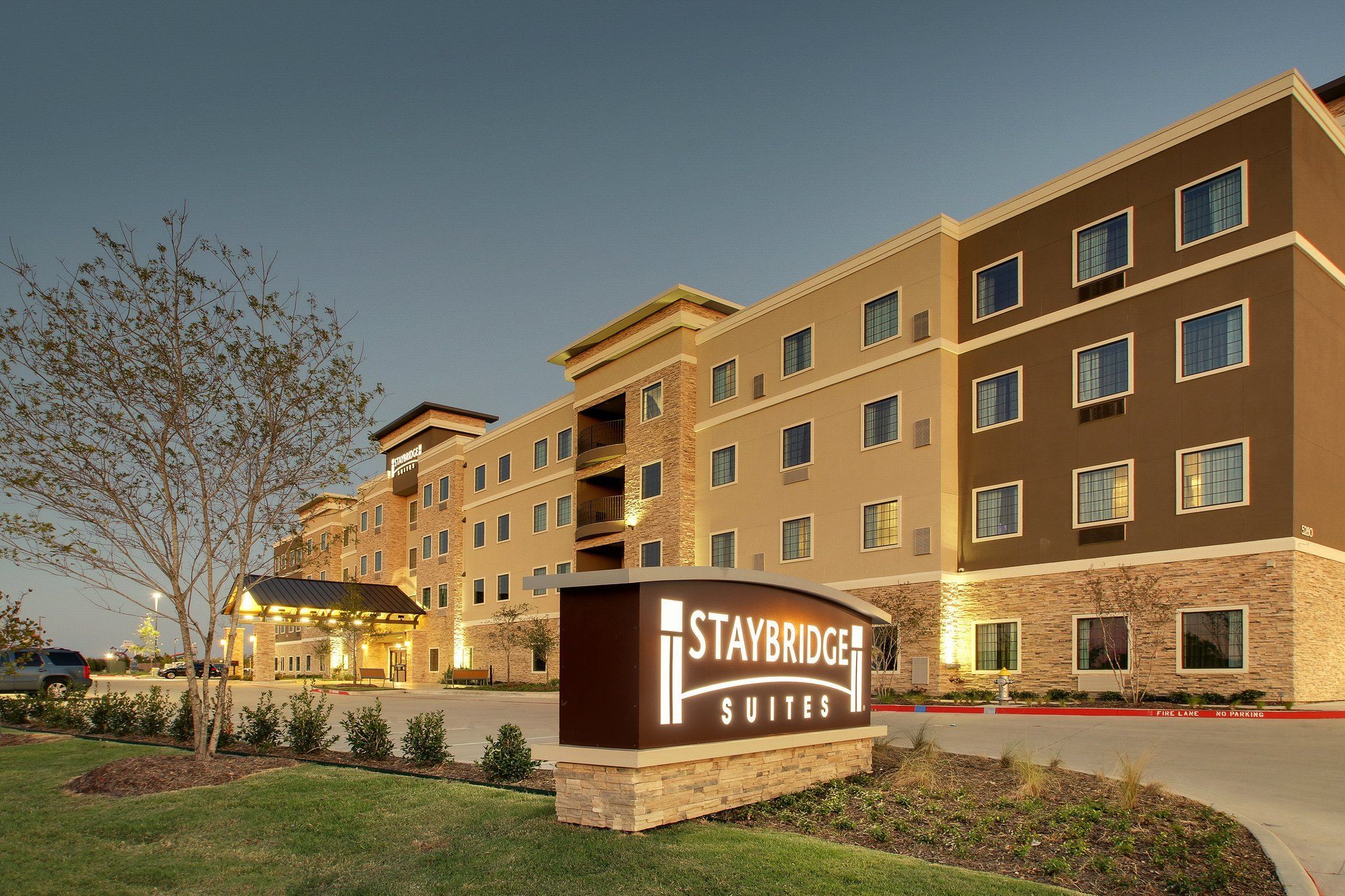 Um hotel Staybridge Suites com placa, vários andares e estacionamento.