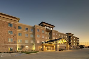 A Staybridge Suites hotel with a modern design, featuring a covered entrance and multiple floors.