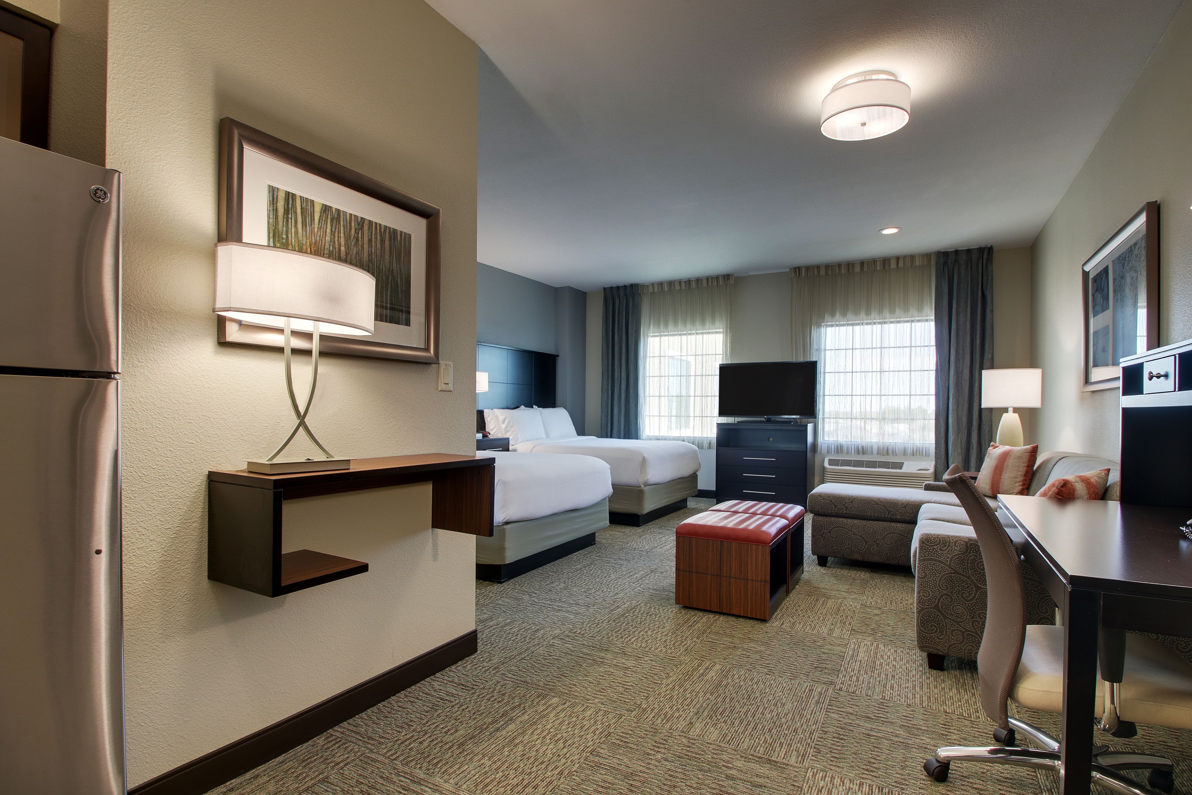 Une chambre d’hôtel équipée d’un lit, d’un bureau, d’une chaise et d’un téléviseur.