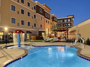 Ein Hotelpoolbereich mit Wasserspiel und Liegestühlen.