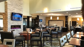 A hotel lobby with multiple seating areas, a fireplace, a TV screen, and a reception desk. - Accessible 1-Bdrm Suite w/ 2 Queens & Pool (The Colony)