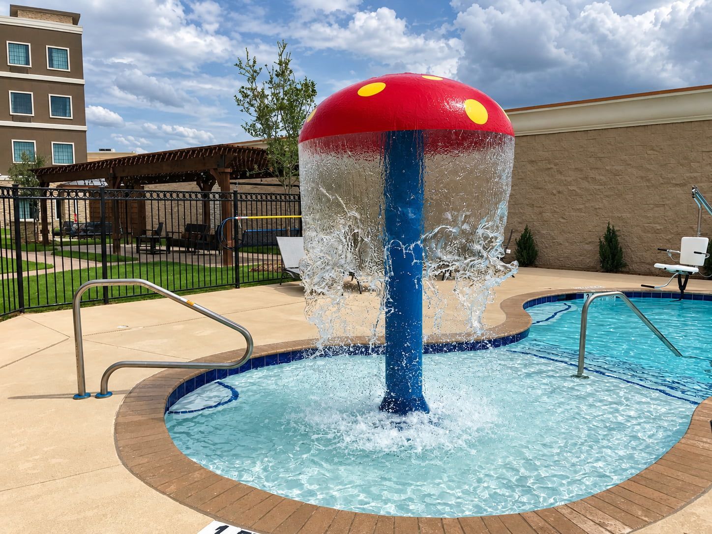 A water feature with a red and blue structure, surrounded by a pool with a wooden deck.