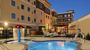 A hotel pool area with a water feature and lounge chairs. - King Studio Suite w/ Kitchen | Free Breakfast! (The Colony)