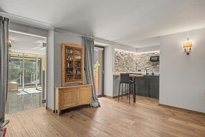 A modern kitchen with a stone backsplash, wooden cabinets, and a bar area.