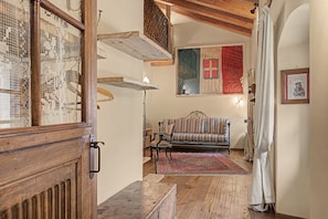 A traditional room with a wooden bench, a striped sofa, and a patterned rug.