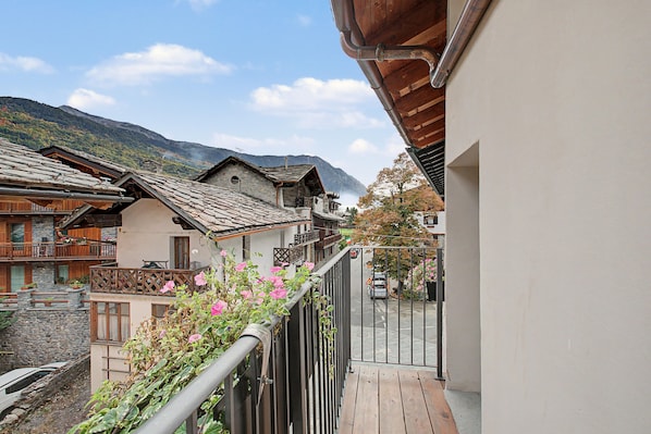 A balcony with a view of traditional buildings and a mountain in the background.