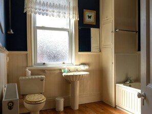 A bathroom with a toilet, sink, and window. - Ryburn Lodge (Bridlington)