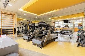 A gym with treadmills, weight machines, and a variety of weights. - E-side By Bhomy (São Paulo)