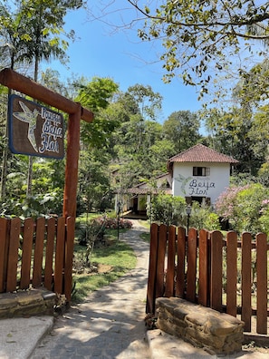 A pathway leading to a building with a sign reading 'Pousada Beija Flor'. - Pousada Beija-flor  (Divino de São Lourenço)