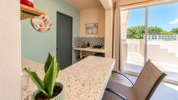 A modern kitchen with a countertop, a sink, and a window with a view of the outdoors.