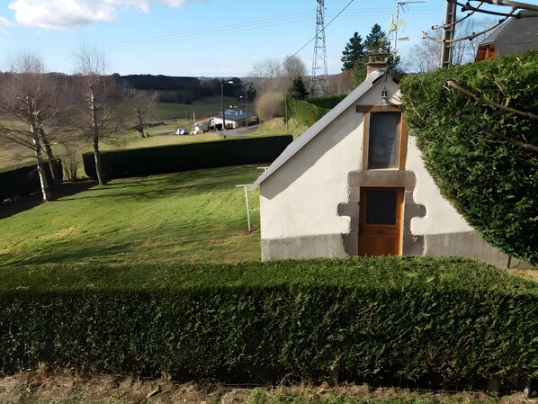 A small, single-story building with a sloped roof, a door, and a window.
