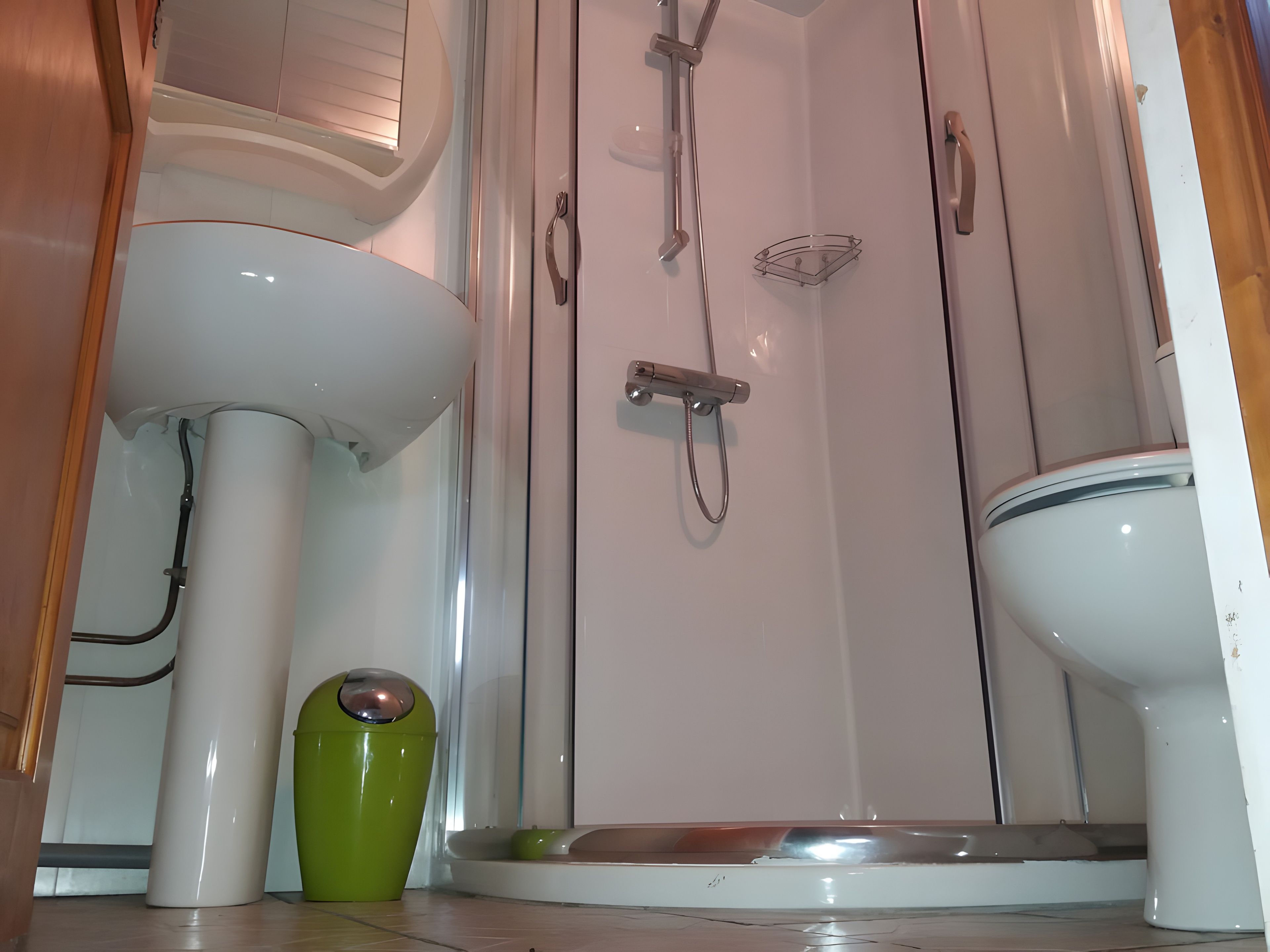 Een badkamer met een wit wastafelmeubel, toilet en douchecabine.