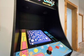 Eine Videospiel-Arcade-Maschine mit einem Labyrinthspiel auf dem Bildschirm.