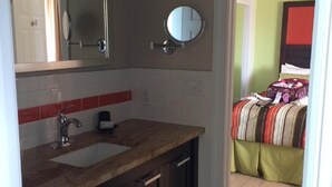 Un baño con lavamanos, espejo y armarios.