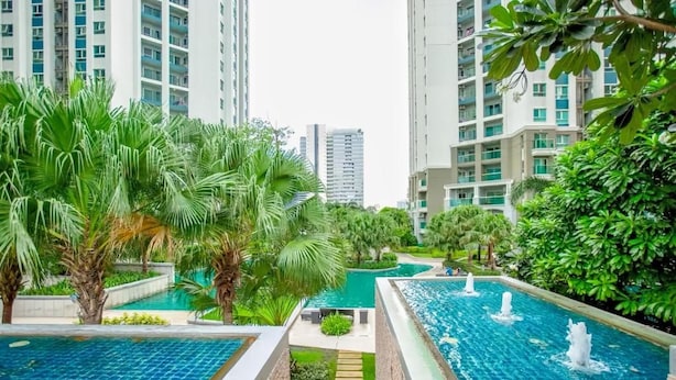 A residential complex with multiple high-rise buildings, a central swimming pool with fountains, and lush greenery. - Belle Grand Rama 9 Bangkok (Krung Thep Maha Nakhon)