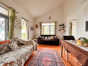 A cozy room with a bed, a sofa, a dining table, and a large window. - 5 min walk to beach, 1 BHK Flat House in Candolim, fully equiped kitchen (Candolim)