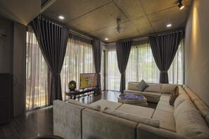 A modern living room with a sectional sofa, a coffee table, and a flat-screen TV.