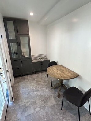 A modern kitchen with grey cabinets, a wooden table, and black chairs. - Peaceful Hilltop Escape in the Heart of LA Cozy (Los Angeles)