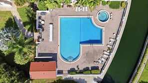 Eine Vogelperspektive auf einen Poolbereich mit Liegestühlen und einem kleinen, runden Pool.