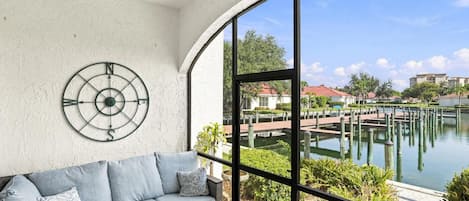 Una habitación con un ventanal grande, un adorno circular en la pared y un sofá gris.
