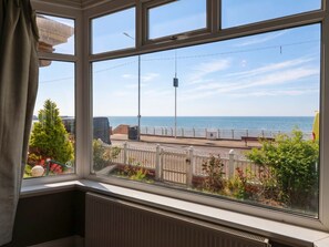 A bay view from a window with a white railing, a street lamp, and a clear sky. - Sunrise Lodge (Bridlington)