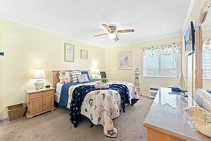 A bedroom with a bed, nightstands, a dresser, a ceiling fan, and a window with blinds. - A Place at the Beach IV 216 Oceanfront 2BR- Pool (Myrtle Beach)