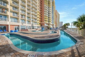Un hôtel doté d’une piscine, de plusieurs balcons et offrant une vue sur l’océan.