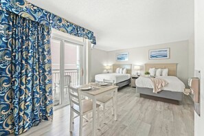 A hotel room with a balcony, two beds, a dining table, and a chair. - Bay Watch Resort 1610 -Efficiency-Great Amenities (North Myrtle Beach)
