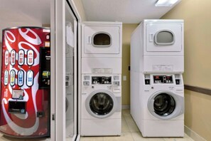 A laundromat with two stacked washing machines and a soda vending machine. - Oceanfront 2BR/2BA -Bay Watch 1509- Great Balcony (North Myrtle Beach)