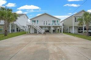 A two-story building with a covered front porch and a staircase leading to the upper level. - Footprints in the Sand - Channel Home w/Swim Spa (North Myrtle Beach)