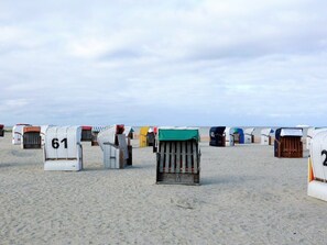 Beach huts numbered 61 and 43, arranged in rows on a sandy beach. - 50.5.n North Berth (Wangerland)