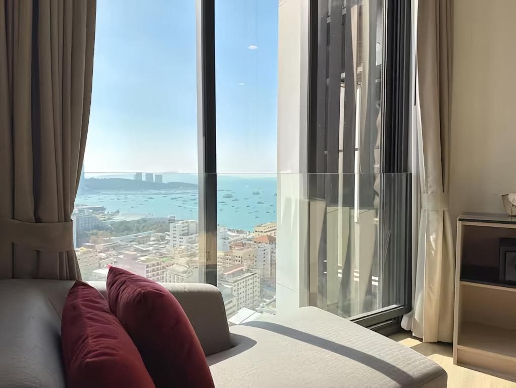 A modern hotel room with a large window offering a city view.