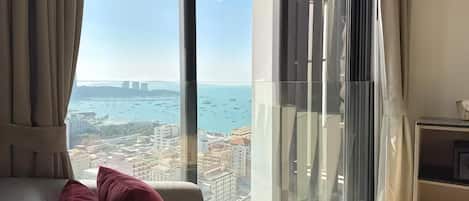 A modern hotel room with a large window offering a city view.