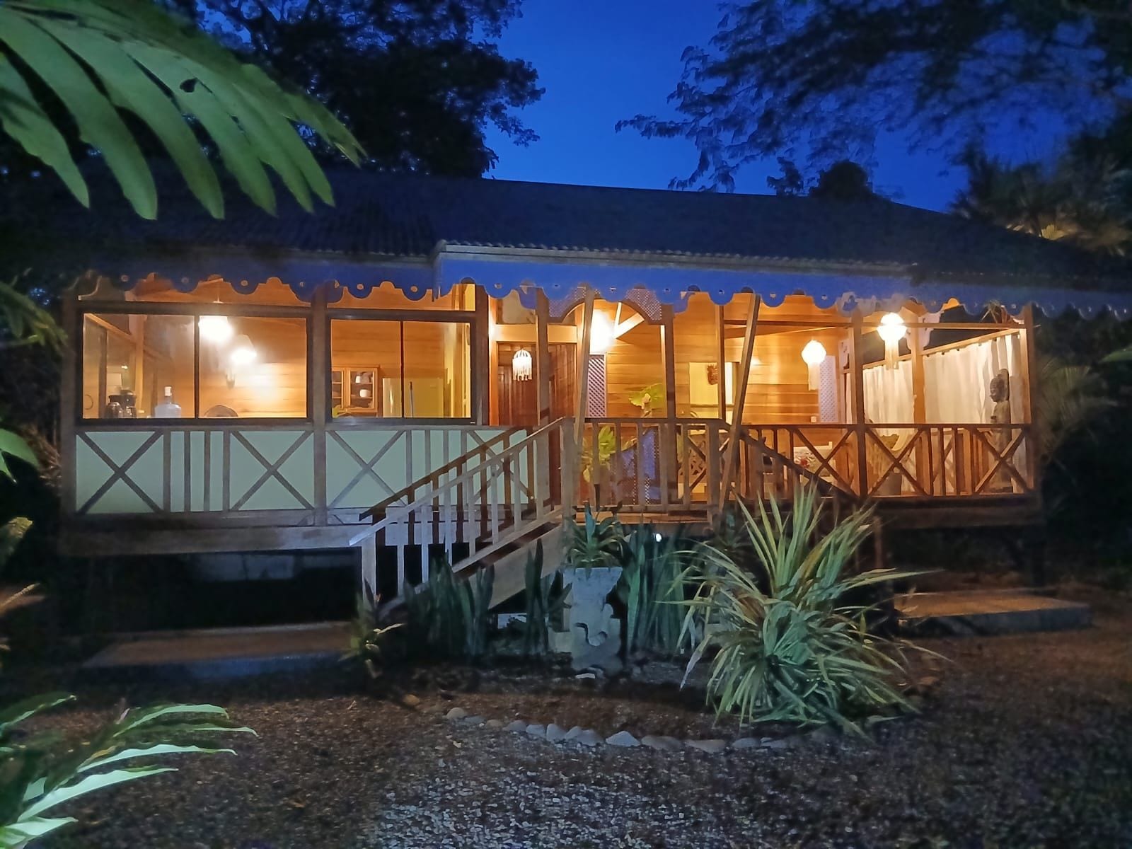 A wooden house with a balcony and a staircase leading to the entrance.