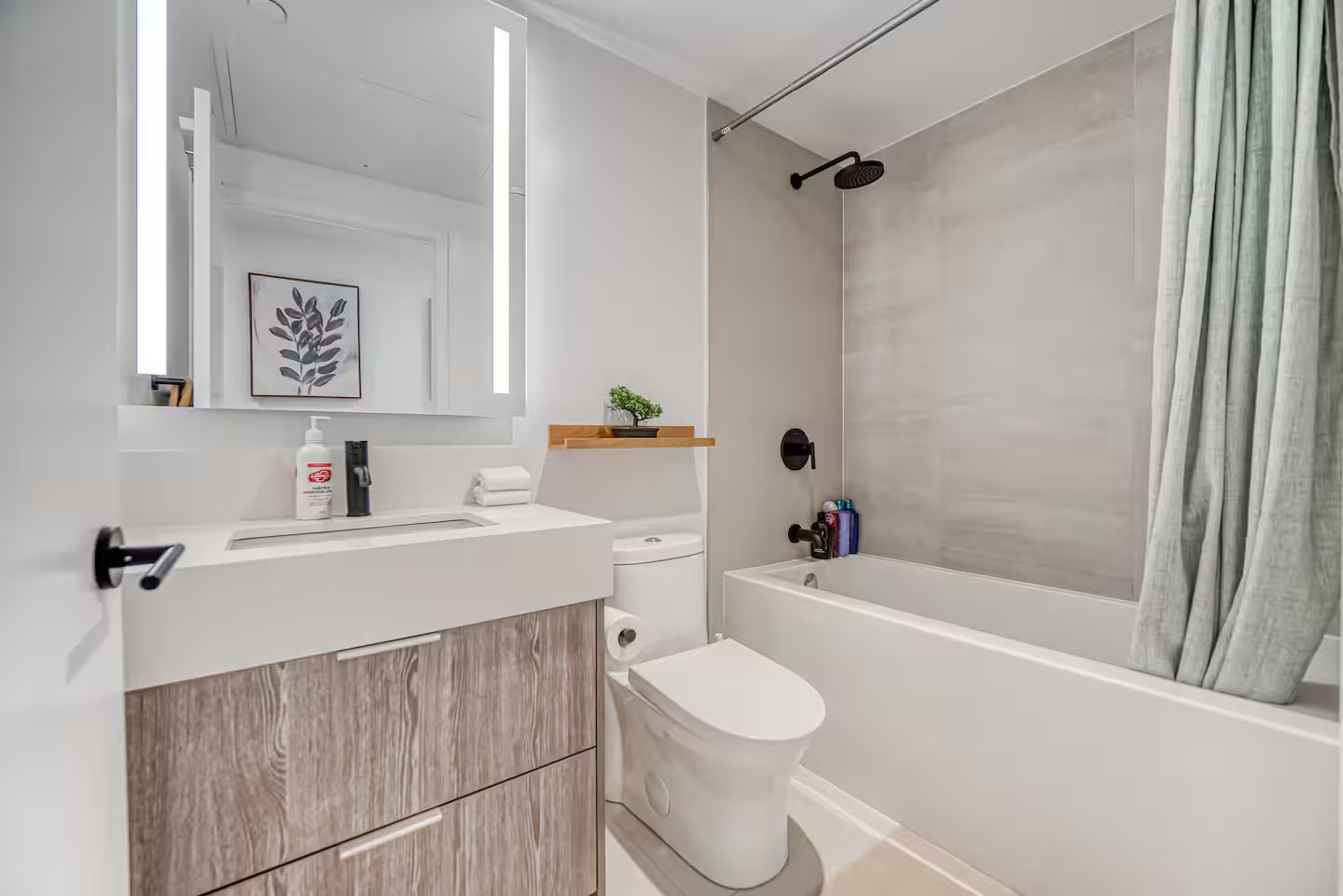 Een moderne badkamer met toilet, wastafel en douche.