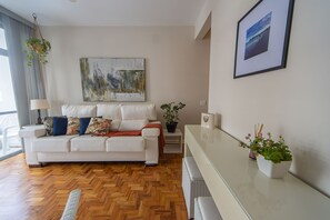 Ein modernes Wohnzimmer mit einem weißen Sofa, einem Couchtisch und einem Gemälde an der Wand.
