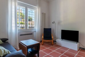 A room with a bed, a small table, a chair, a TV on a stand, and a window with a view of buildings. - Apartment located on the ground floor (10 steps to access) of a typical period building (NOT suitable for disabled people) overlooking the Basilica of St. John Lateran.In 55 sqm of space it comfortably accommodates 3 people.Conveniently located a short d (Roma)