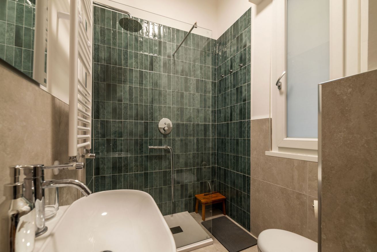 Ein Badezimmer mit Dusche, Waschbecken und Toilette.