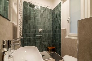 Une salle de bain avec une douche, un lavabo et des toilettes.