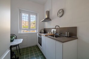 A compact kitchen with a window, a stove, a sink, and a clock on the wall. - Apartment located on the ground floor (10 steps to access) of a typical period building (NOT suitable for disabled people) overlooking the Basilica of St. John Lateran.In 55 sqm of space it comfortably accommodates 3 people.Conveniently located a short d (Roma)