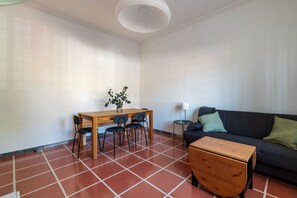 A room with a dining table, chairs, a sofa, a small side table, and a lamp. - Apartment located on the ground floor (10 steps to access) of a typical period building (NOT suitable for disabled people) overlooking the Basilica of St. John Lateran.In 55 sqm of space it comfortably accommodates 3 people.Conveniently located a short d (Roma)