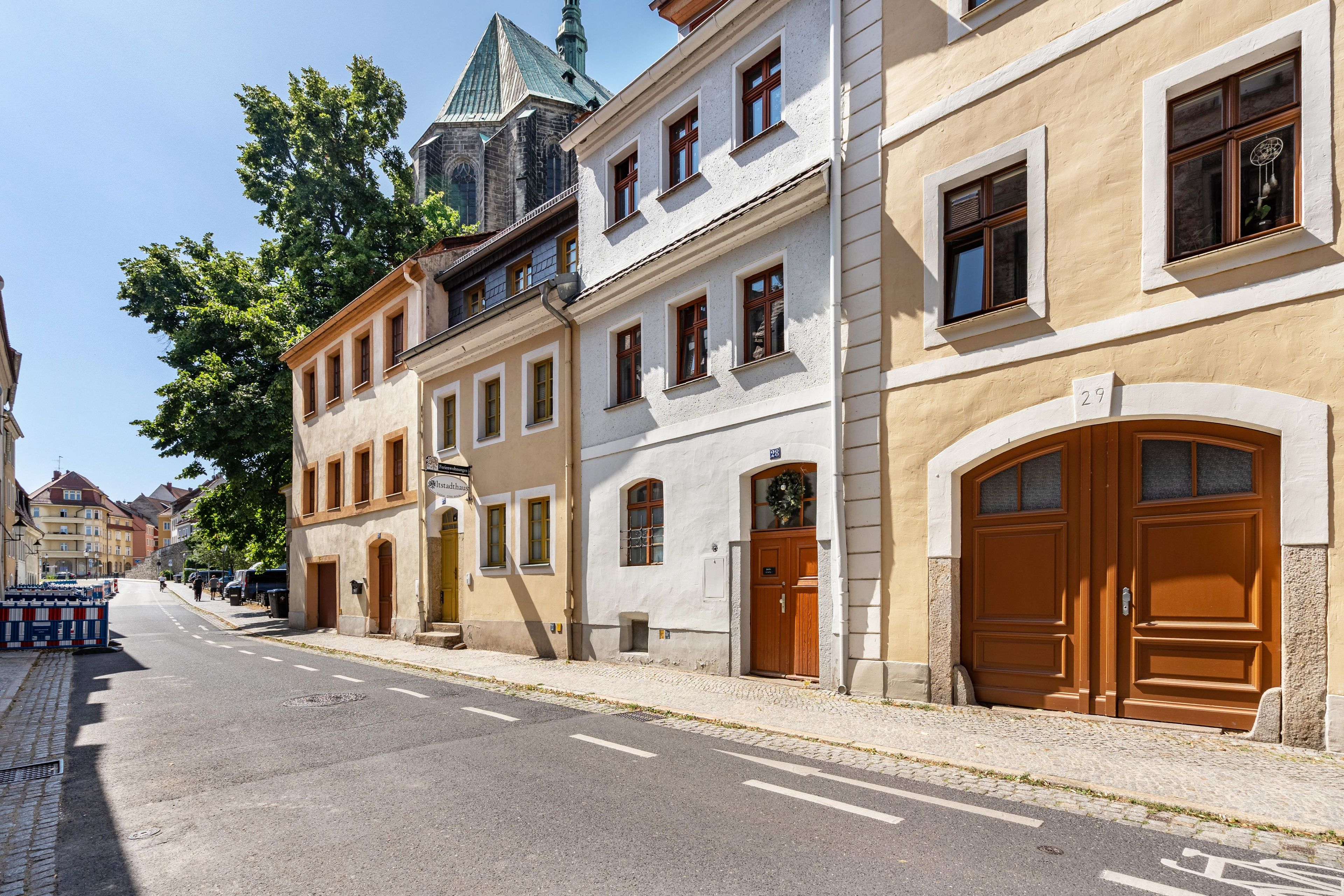 A street view with historic buildings, a cobblestone street, and a clear sky.