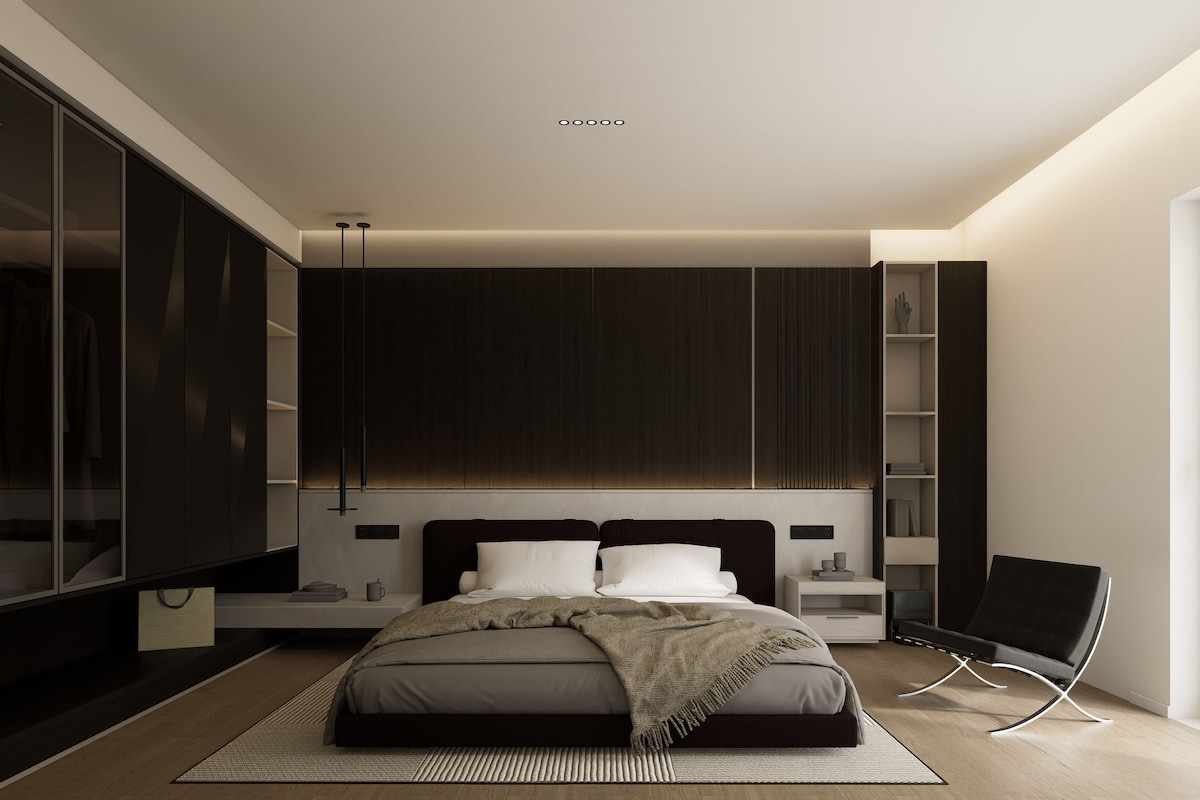 A modern bedroom with a bed, bedside tables, a wardrobe, and a chair.
