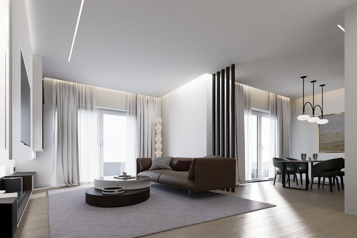 A modern living room with a sofa, a coffee table, and a dining area with chairs.