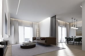 A modern living room with a sofa, a coffee table, and a dining area with chairs. - F&R Zimmervermietung  (Tappenbeck)