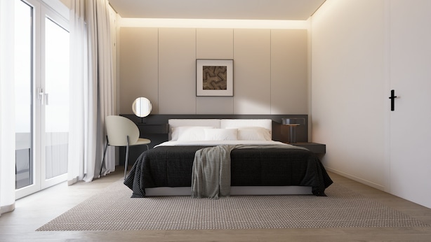 Un dormitorio moderno con cama, mesita de noche, silla y un ventanal grande.