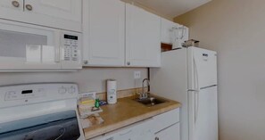 Una cocina compacta equipada con microondas, pileta y refrigerador.