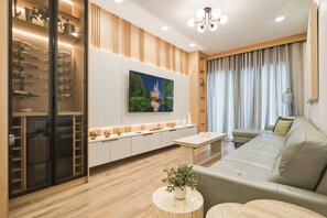 A modern living room with a sofa, a coffee table, and a TV mounted on the wall. - 5BR Villa Near Disney, Universal & SeaWorld! (Orlando)